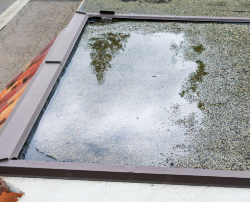 Ponding standing water on a flat roof after heavy rain