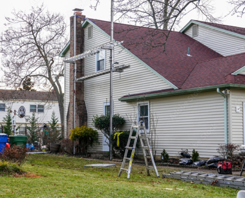 Scaffolding and ladder set up on the side of a home to allow residing of the house