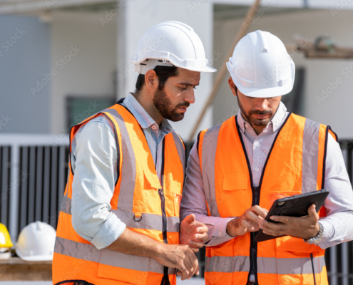 Team engineer and architects are meeting to plan for new project measuring layout of building blueprints in construction site,Construction residential new house in progress at building site.