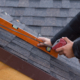 Roofer holding a tape measure and level