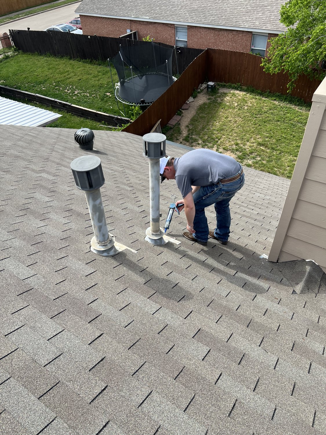 Davis Roofing Solutions technician resealing a vent boot during a roof maintenance visit in Dallas-Fort Worth