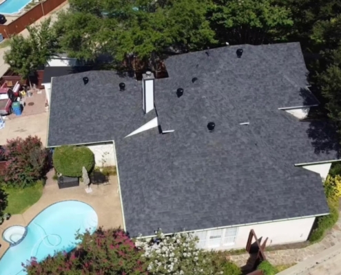 Aerial of a home with a new charcoal shingle roof beside a backyard pool