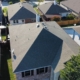 Drone view of a completed gray shingle roof among homes in a North Texas neighborhood