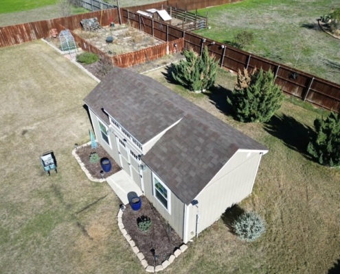 Aerial of a backyard workshop shed with a freshly installed brown shingle roof