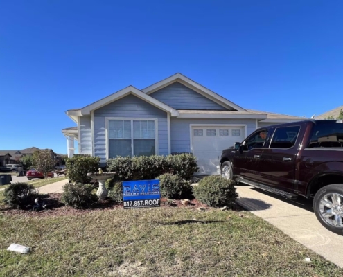 Light-blue sided home with a new shingle roof and fresh gutters, a pickup parked in the driveway.