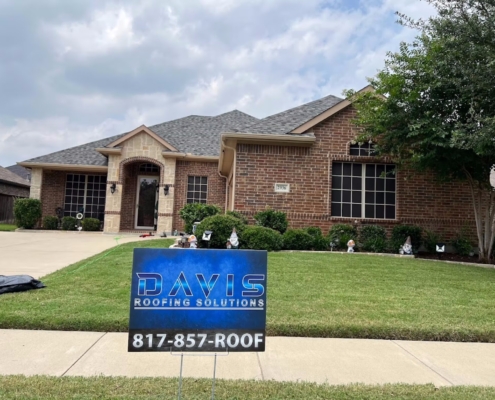 Single-story brick home with a completed shingle roof and neat landscaping