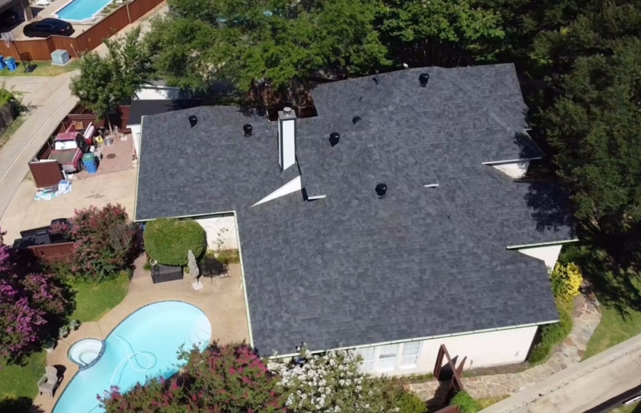 Aerial of a completed charcoal shingle roof overlooking a backyard pool