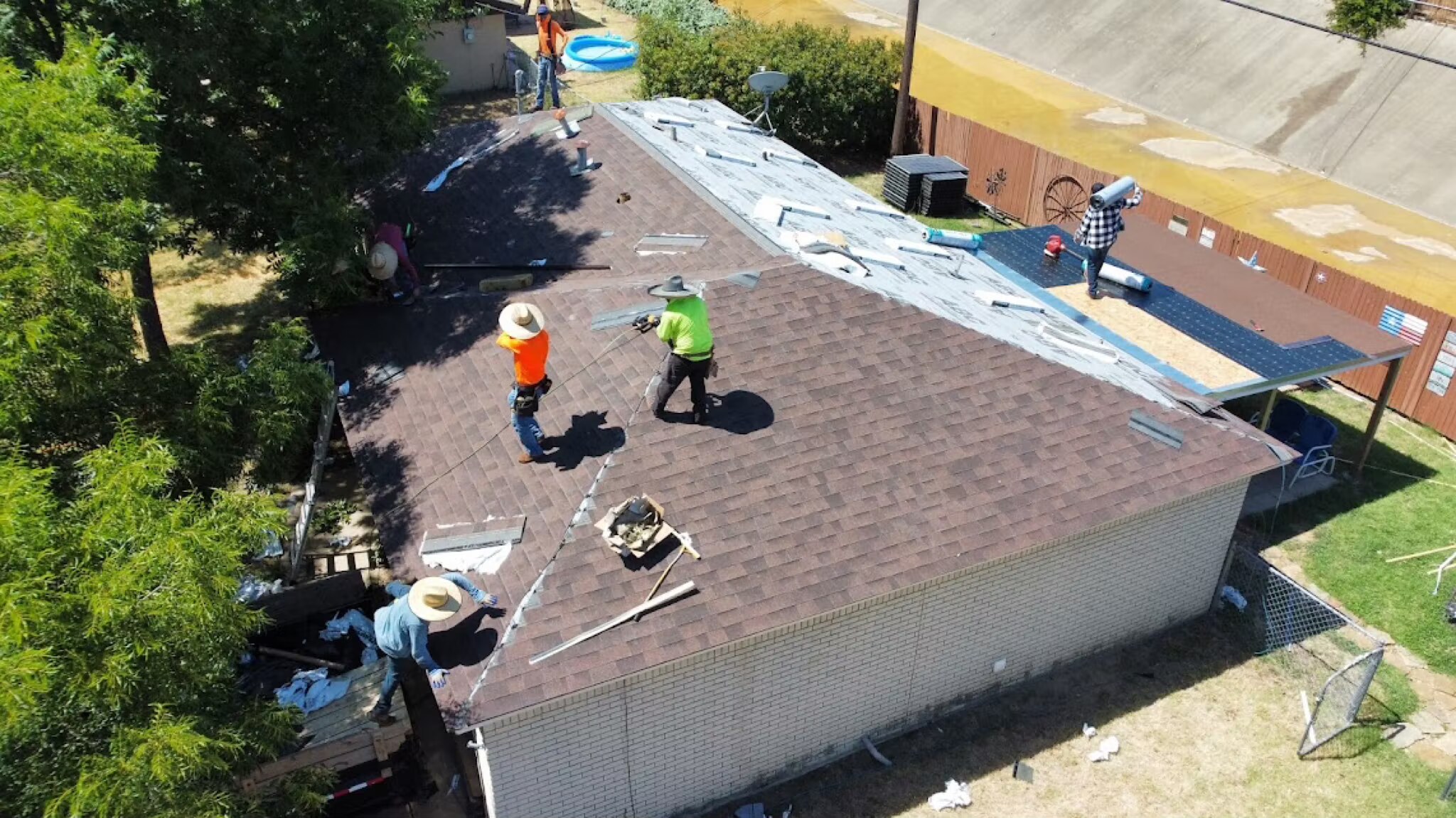 Davis Roofing Solutions crew working on a brown shingle roof in the Dallas-Fort Worth area