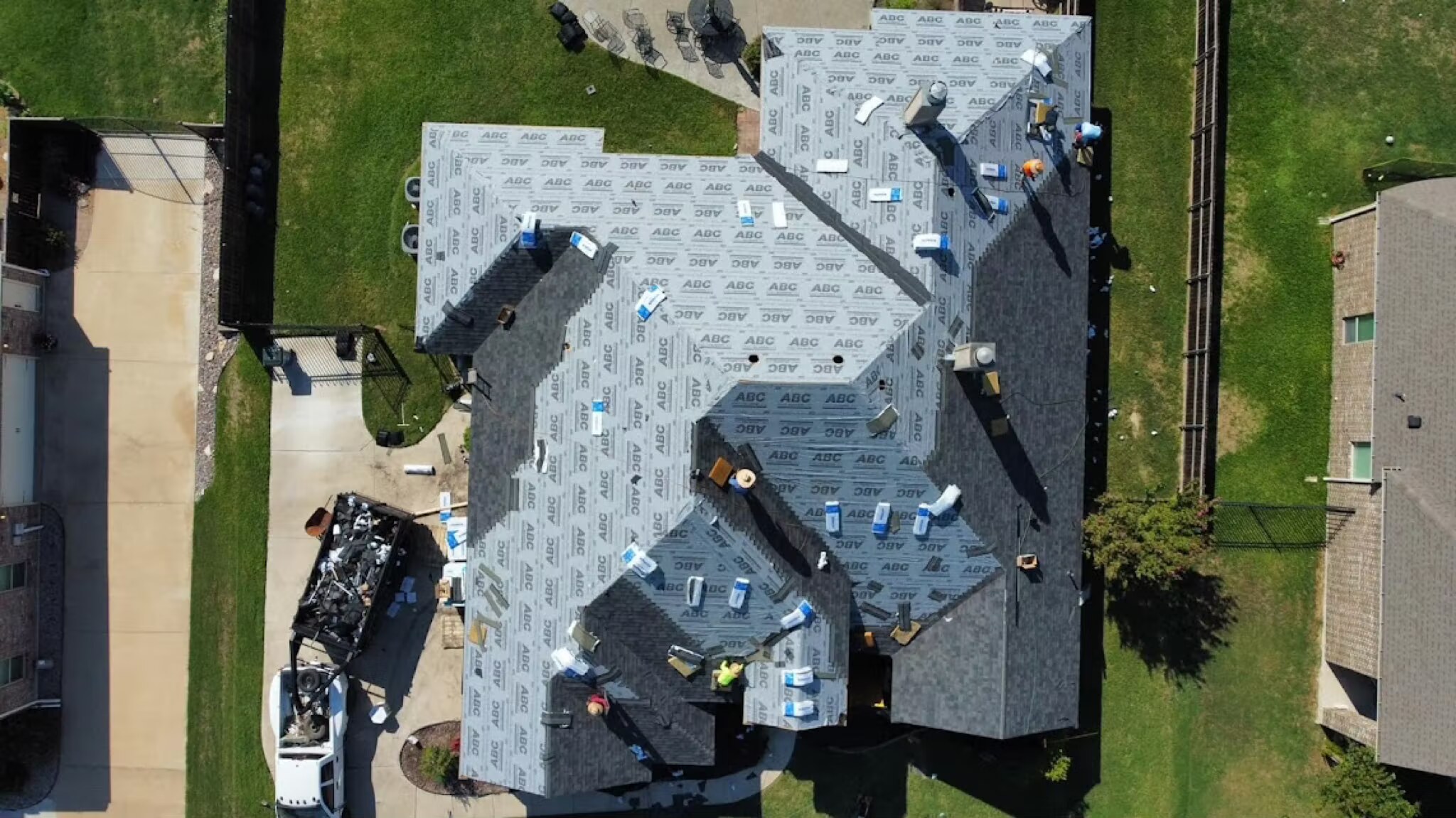 Aerial view of a Davis Roofing Solutions crew mid-installation on a large DFW roof