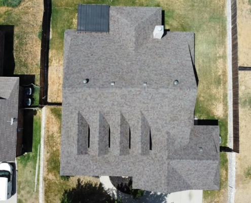 Overhead drone view of a completed weathered-wood shingle roof