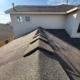 Close view of new ridge-cap shingles running along the peak of a freshly roofed home