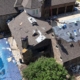 Overhead view of a roof replacement in progress with synthetic underlayment and shingle bundles staged