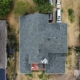 Overhead drone shot of a finished gray shingle roof on a suburban home