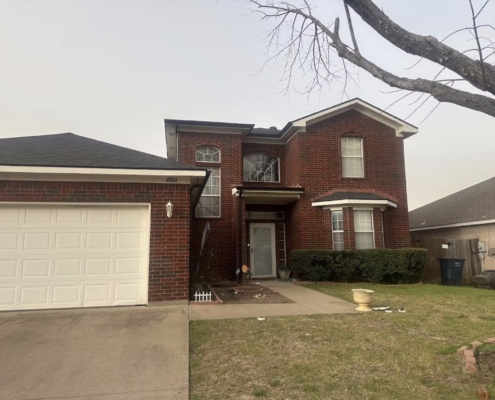 Two-story red brick home with a newly installed dark shingle roof and attached garage
